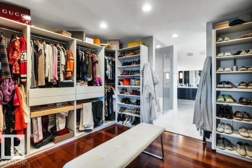 Spacious walk-in closet featuring extensive built-in shelving, hanging rods, recessed lighting, and rich wood-finish flooring - 8914 120 Street, Edmonton, AB 