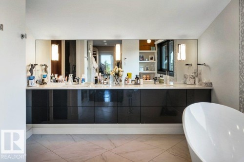 Contemporary bathroom featuring a long vanity with dual sinks, a large integrated mirror, and sleek black cabinetry - 8914 120 Street, Edmonton, AB 