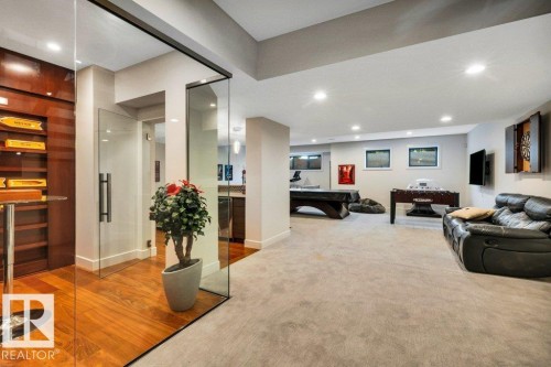 Spacious entertainment area featuring recessed lighting, a combination of wood-finish flooring and carpeted areas, and multiple window openings - 8914 120 Street, Edmonton, AB 
