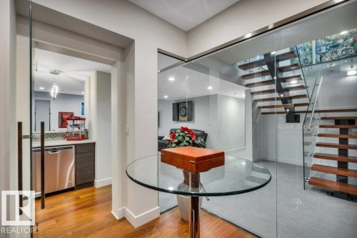 Contemporary glass-enclosed staircase with wood-finish treads and metal risers - 8914 120 Street, Edmonton, AB 
