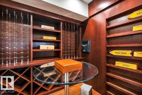 Custom built-in wine storage system with rich wood cabinetry, integrated shelving, and a central glass-top table - 8914 120 Street, Edmonton, AB 