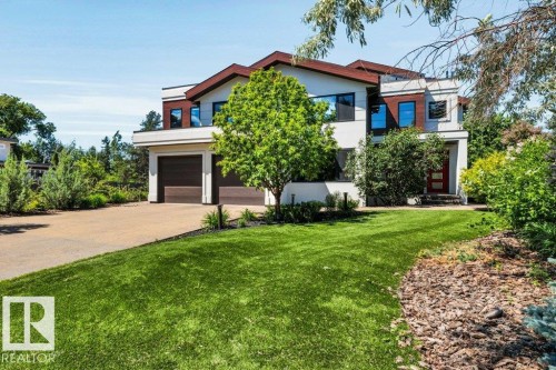 Contemporary multi-story residence featuring a two-car garage, expansive driveway, and a red entry door - 8914 120 Street, Edmonton, AB 