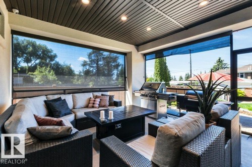 Covered patio featuring a slatted ceiling, recessed lighting, and retractable screens - 8914 120 Street, Edmonton, AB 