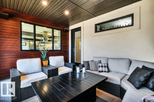 Covered patio with a slatted dark wood ceiling and recessed lighting - 8914 120 Street, Edmonton, AB 