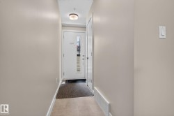 Entrance featuring a white door with sidelight window, flush-mount ceiling light, light-toned wall paint, and tile flooring - 