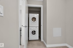 Dedicated laundry area featuring a stacked washer and dryer - 