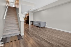 Open-concept living space with wood-finish flooring - 