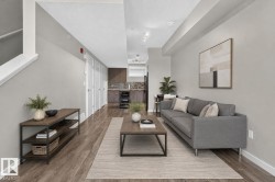 Open concept living area featuring wood-finish flooring, light gray wall tones, and recessed lighting - 