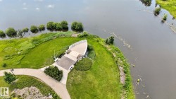 Waterfront observation deck with a boat-like design, featuring a paved surface and surrounding green space - 