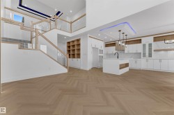 Open-concept living area with herringbone wood-finish flooring - 
