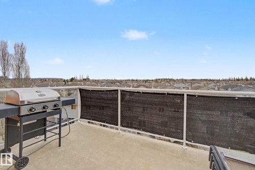 Spacious outdoor balcony featuring a concrete surface and a partial privacy screen - 415 263 Macewan Road, Edmonton, AB 