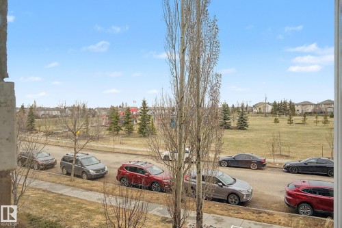Expansive green space featuring mature trees and distant residential structures - 415 263 Macewan Road, Edmonton, AB 