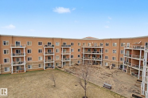Multi-level building with individual balconies featuring glass railings - 415 263 Macewan Road, Edmonton, AB 
