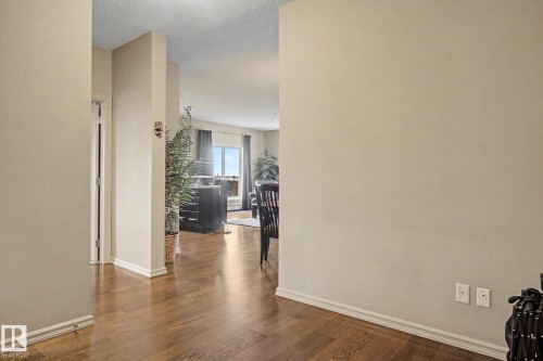 Wood-finish flooring throughout, light neutral wall paint, and white baseboards - 415 263 Macewan Road, Edmonton, AB 
