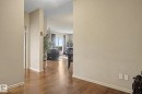 Wood-finish flooring throughout, light neutral wall paint, and white baseboards - 415 263 Macewan Road, Edmonton, AB 