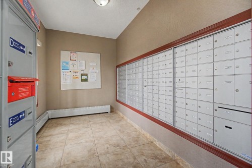Mailroom area featuring extensive individual mailboxes, a dedicated mail drop, and a bulletin board - 415 263 Macewan Road, Edmonton, AB 