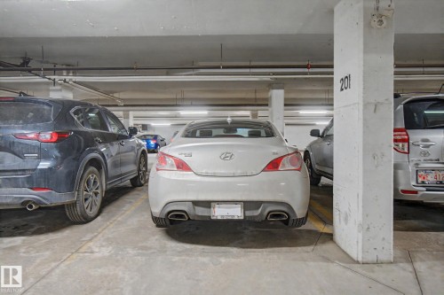 Underground parking space featuring concrete pillars and ceiling, overhead lighting, and designated parking lines - 415 263 Macewan Road, Edmonton, AB 