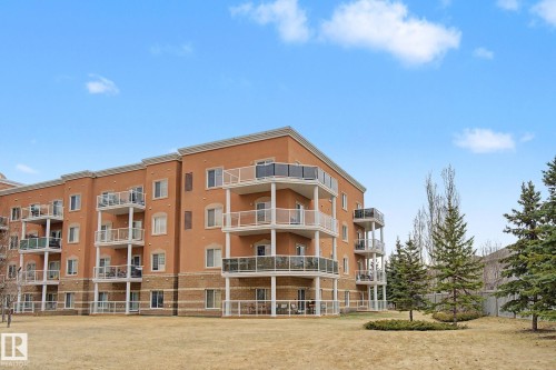 Stucco and brick facade condominium building featuring private balconies with glass railings - 415 263 Macewan Road, Edmonton, AB 