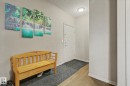 Entryway featuring wood-finish flooring, light neutral wall paint, and a flush-mount ceiling light fixture - 415 263 Macewan Road, Edmonton, AB 