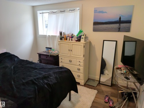 Room featuring wood-finish flooring, a neutral wall color, and a window with white curtains - 31 Brown Street, Stony Plain, AB 