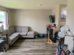 Spacious living area featuring wood-finish flooring and neutral wall tones - 