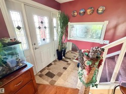 Entryway featuring a white door with decorative glass inserts and sidelights - 