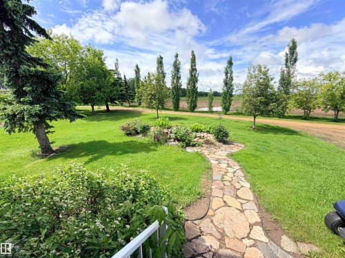 Expansive green lawn with a natural stone pathway - 26418 Twp Rd 633, Rural Westlock County, AB 