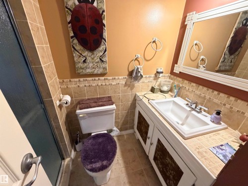 Bathroom featuring a white vanity with an integrated sink, brushed nickel faucet, and decorative cabinet door inserts - 26418 Twp Rd 633, Rural Westlock County, AB 