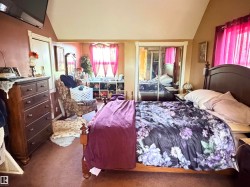 Carpeted room featuring a window with natural light, a mirrored sliding closet door, and an angled ceiling - 
