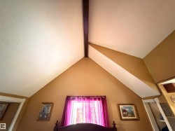 Vaulted ceiling with exposed wood beam and angled walls - 