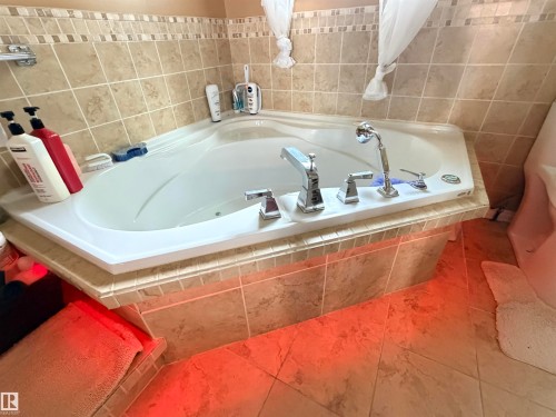 Corner soaking tub with polished chrome fixtures and a handheld shower sprayer - 26418 Twp Rd 633, Rural Westlock County, AB 