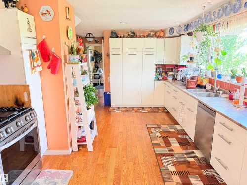 Full kitchen featuring wood-finish flooring and ample white cabinetry - 26418 Twp Rd 633, Rural Westlock County, AB 