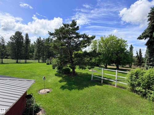 Expansive green lawn featuring mature trees and a white three-rail fence - 26418 Twp Rd 633, Rural Westlock County, AB 