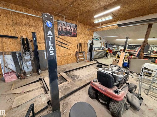 Workshop space featuring an Atlas Equipment lift and concrete flooring - 26418 Twp Rd 633, Rural Westlock County, AB 