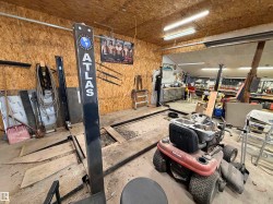 Workshop space featuring an Atlas Equipment lift and concrete flooring - 