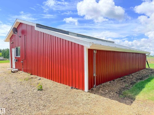 Red metal-sided outbuilding with white trim and a metal roof - 26418 Twp Rd 633, Rural Westlock County, AB 