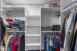 Custom closet organization system featuring white shelving, multiple hanging rods, and integrated vertical storage compartments - 
