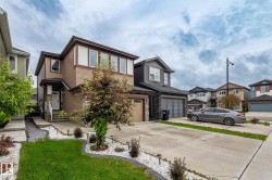 Contemporary two-story residence featuring a two-car garage and a paved driveway - 