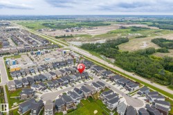 Aerial perspective of a developed residential community featuring rows of contemporary homes with dark-toned roofs - 