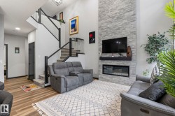 Two-story living area featuring a stacked stone fireplace with a linear insert and a floating mantel - 