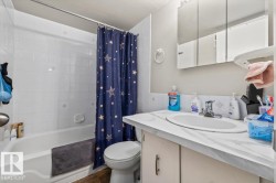 Bathroom featuring a white bathtub with tile surround, vanity with an integrated sink, and a mirrored medicine cabinet - 