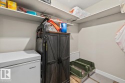 Recessed storage area featuring multiple wall-mounted shelves, light beige wall paint, and white baseboards - 