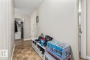 Entryway featuring neutral wall paint, textured ceiling, tiled flooring, and a white door with silver hardware - 202 10330 113 Street, Edmonton, AB 