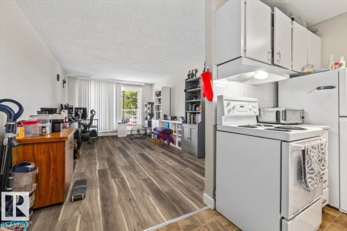 Kitchenette with white cabinetry, included range, and refrigerator - 202 10330 113 Street, Edmonton, AB 