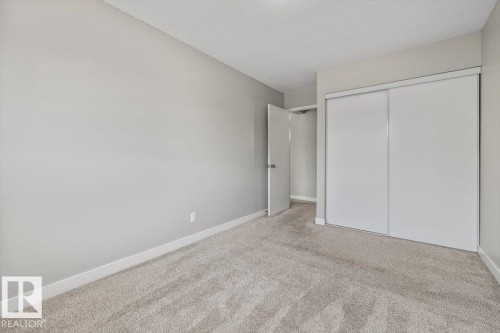 Bedroom featuring plush carpeting, light gray wall paint, and white trim - 306 10330 113 Street, Edmonton, AB 
