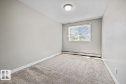 Carpeted room with light neutral wall paint, white trim, a single window with blinds, and a flush-mount ceiling light fixture - 