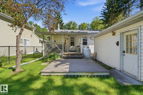 Backyard featuring an expansive wood deck, covered porch, and detached garage with an exterior door - 1410 47436 Range Rd. 15, Rural Leduc County, AB 