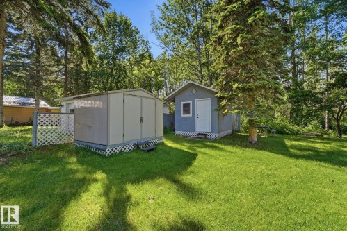 Expansive green lawn with two detached sheds and mature trees - 1410 47436 Range Rd. 15, Rural Leduc County, AB 