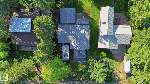 Property featuring an asphalt shingle roof, a multi-level deck, and surrounding mature trees - 1410 47436 Range Rd. 15, Rural Leduc County, AB 
