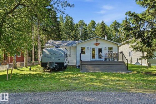 White siding residence featuring a spacious rear deck with composite decking and dark railings - 1410 47436 Range Rd. 15, Rural Leduc County, AB 